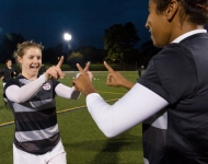 two soccer players point fingers at one another